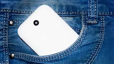 White smartphone in back pocket of blue jeans.