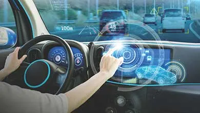 Inside a futuristic car, a person uses a large dashboard touchscreen. Augmented reality on the windshield highlights other vehicles and displays driving data.