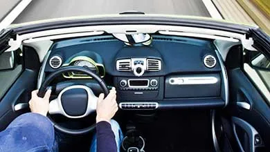 View from the driver's seat of a moving convertible on a highway.