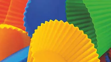 Close-up of colorful fluted cupcake liners in yellow, blue, green, and orange.